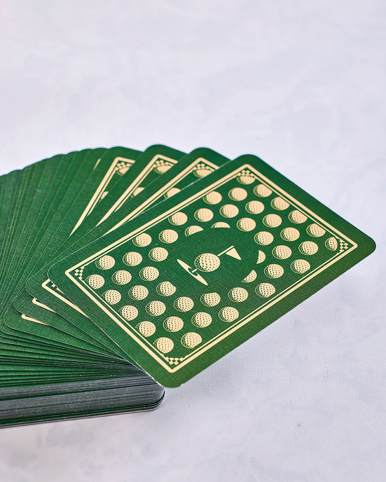 Fan of green playing cards showing a golf-ball-and-flag design on the card backs.