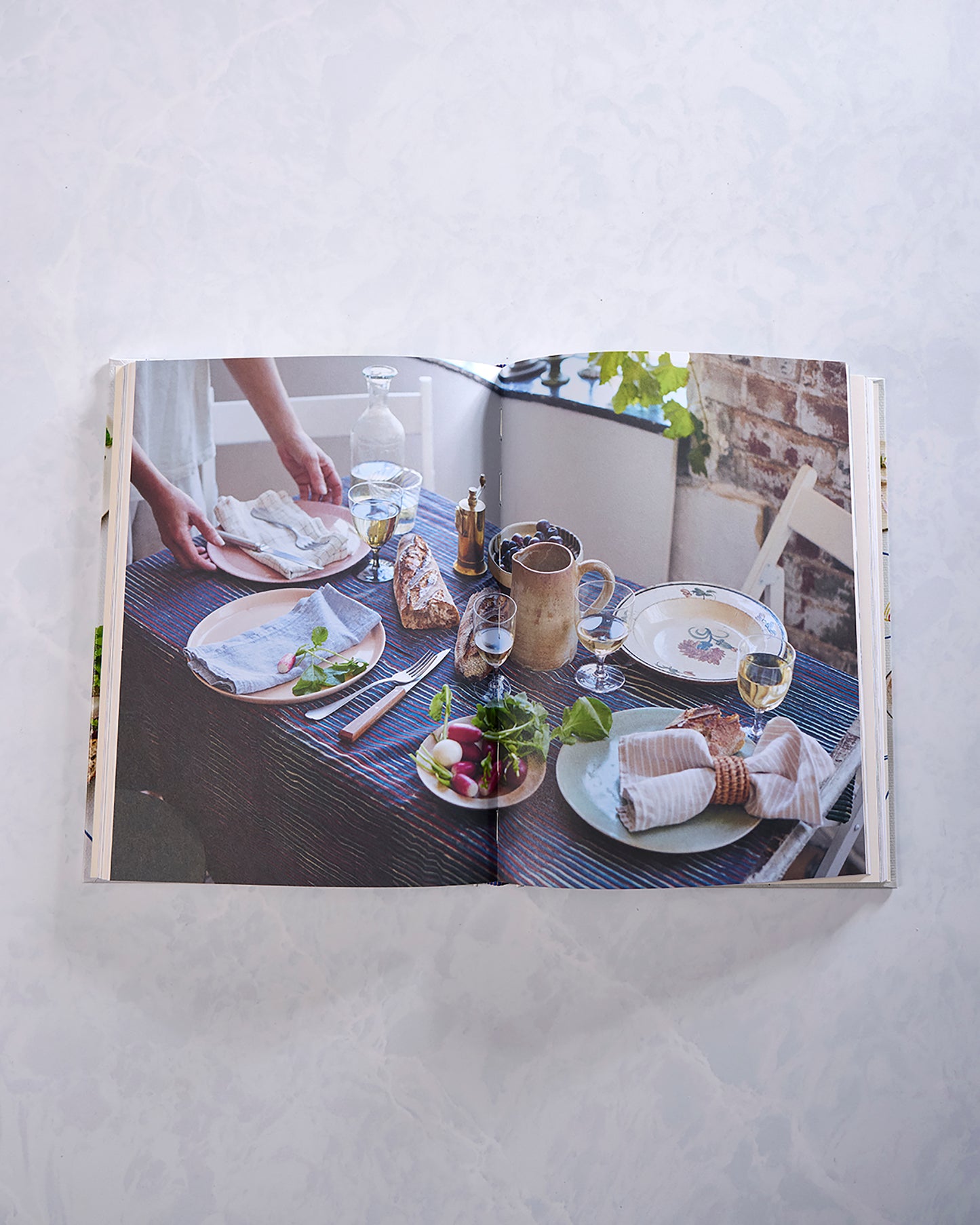 Open Last Minute Dinner Party cookbook showing a styled dinner table with plates, bread, vegetables, drinks, and table settings.