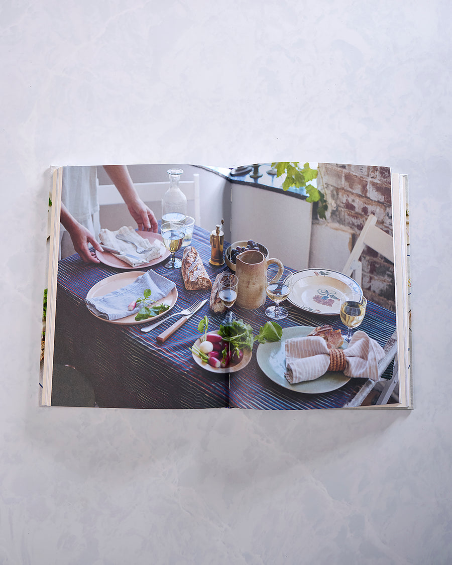 Open Last Minute Dinner Party cookbook showing a styled dinner table with plates, bread, vegetables, drinks, and table settings.