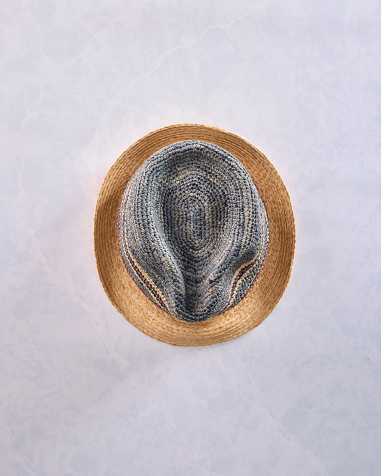 Top view of a crocheted fedora with a natural-colored brim and a blue-gray striped crown.