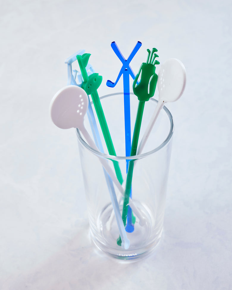 Five colorful golf-themed stir sticks displayed upright in a clear glass.