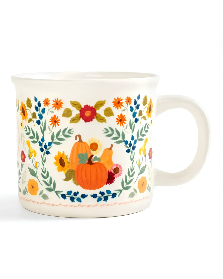 White mug with a colorful floral border and pumpkin illustrations, shown from the front.