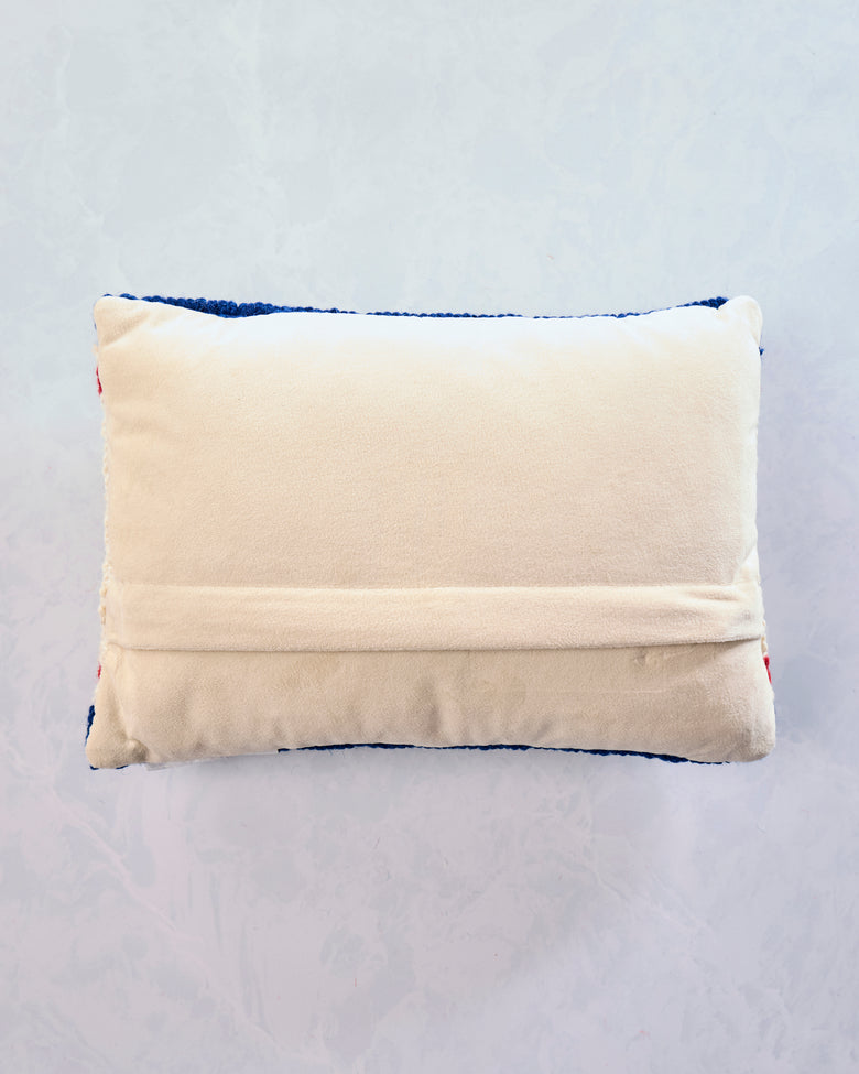 Back view of the red, white, and blue Americana Stars USA lumbar pillow, showing its cream velvet backing and zipper flap.