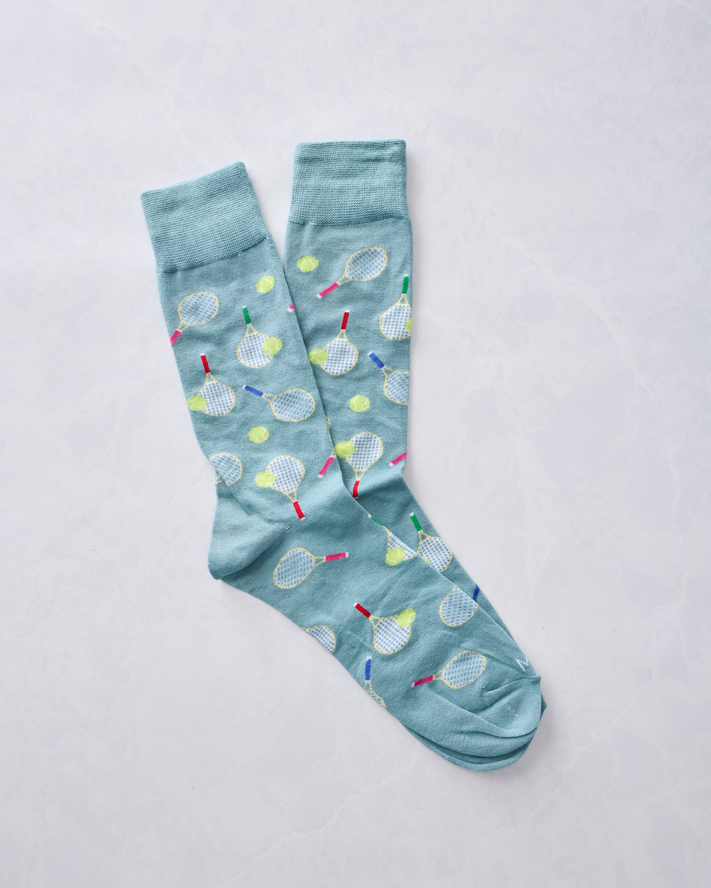 Overlapping blue crew socks with tennis racket and ball print
