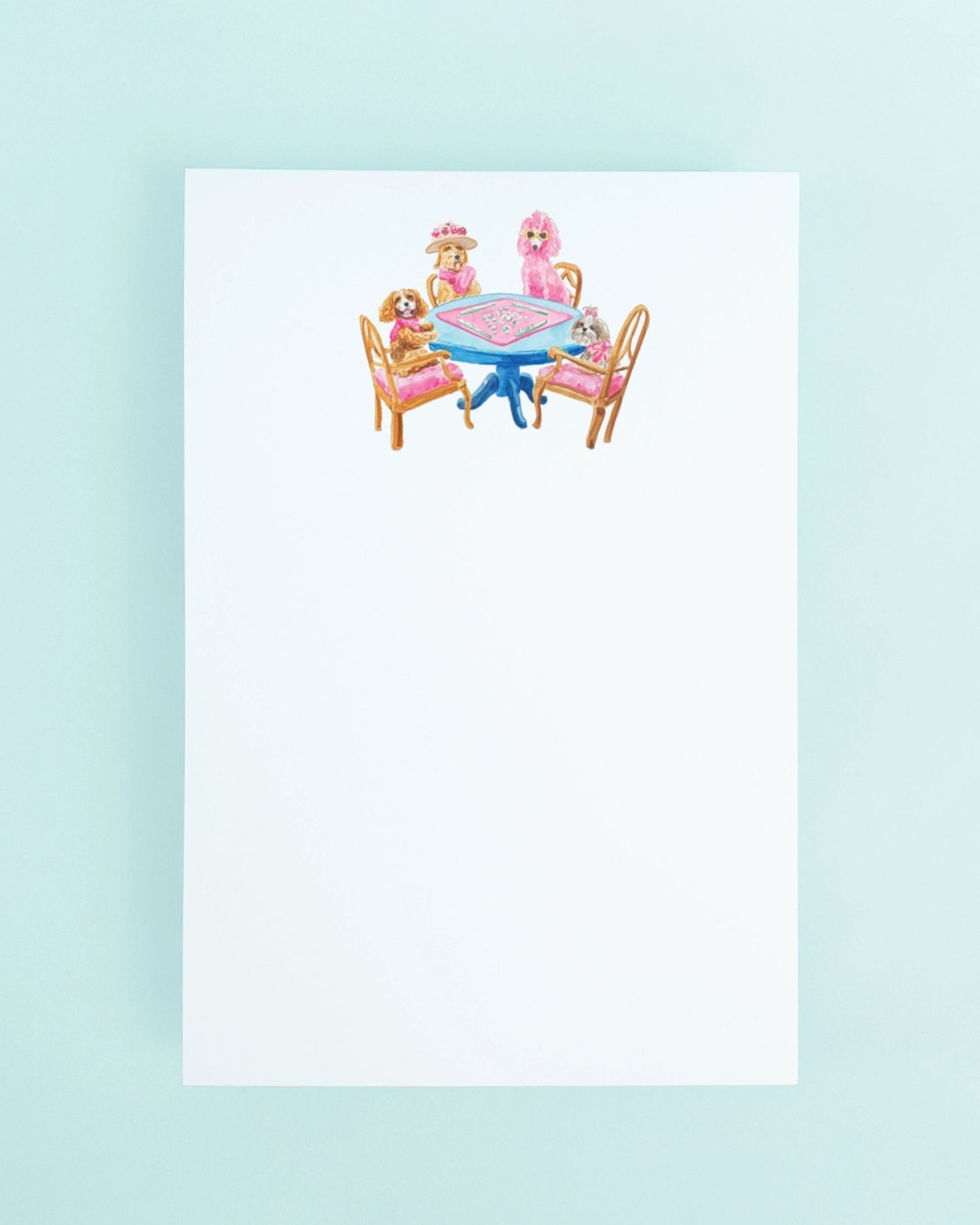 White top-bound notepad with an illustration of dogs seated around a blue table playing mahjong.