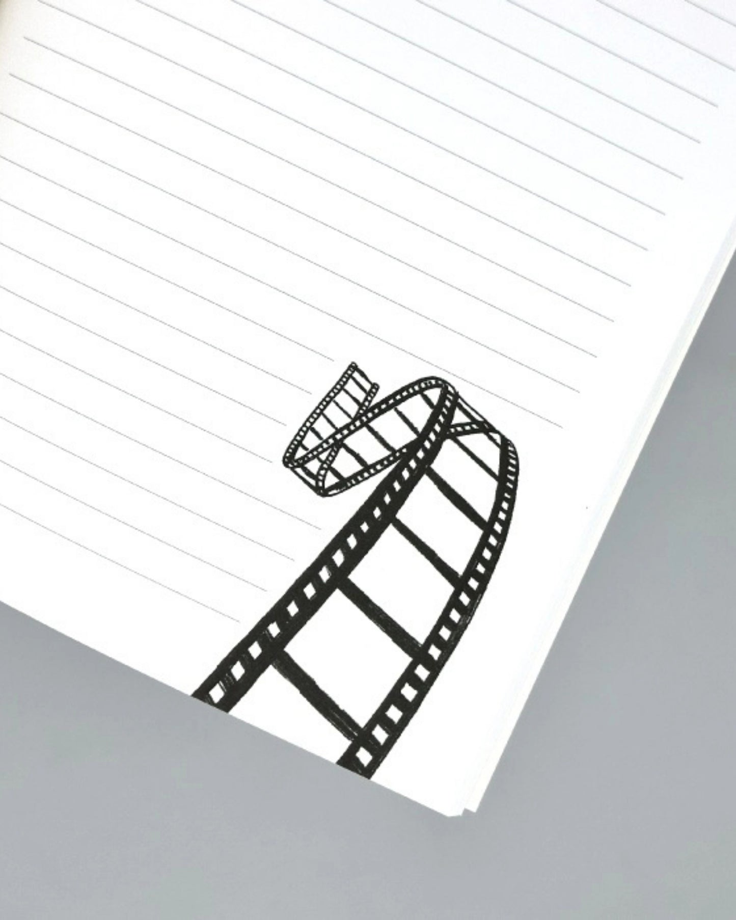 Lined journal page with a black-and-white film-strip illustration