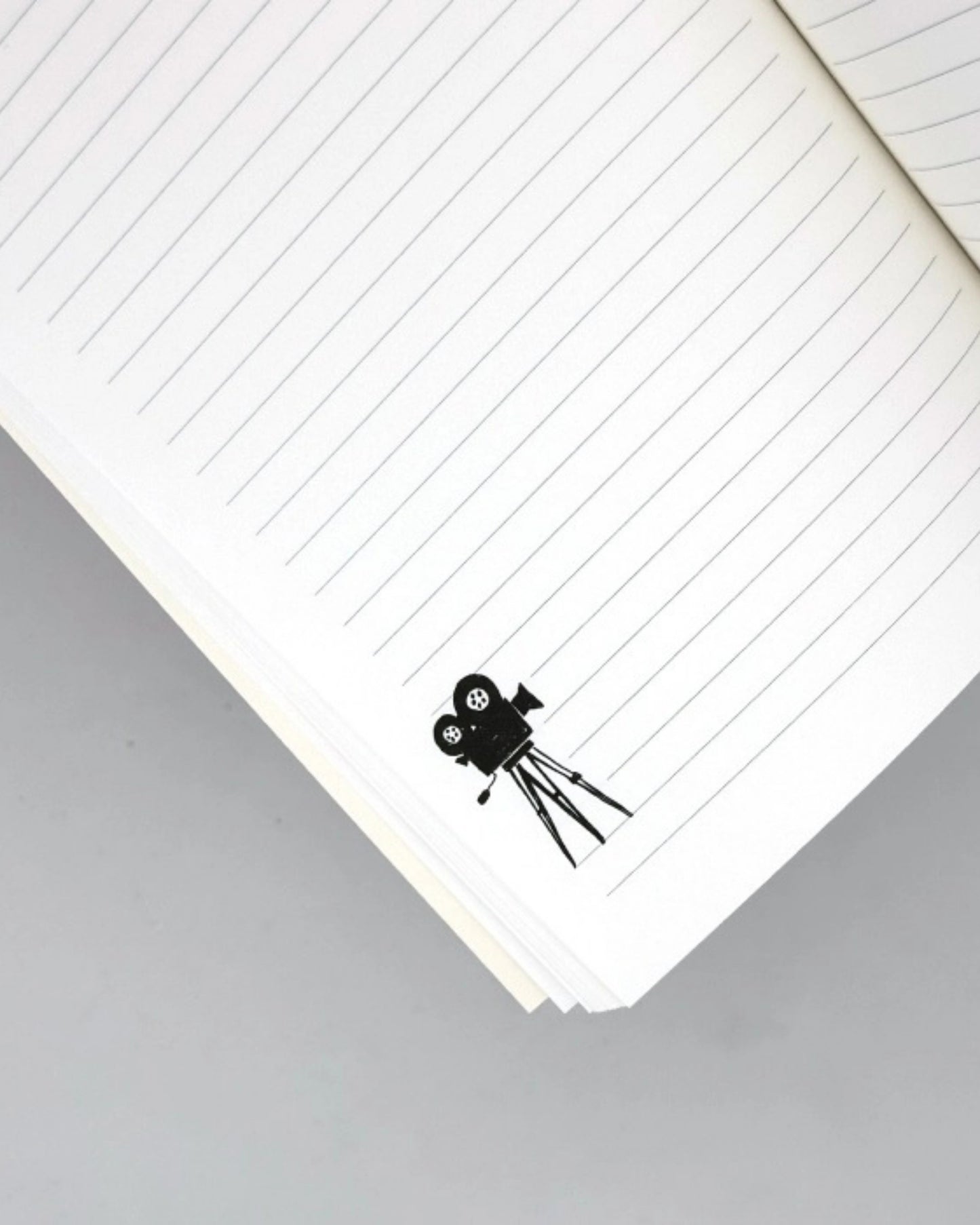 Lined journal page with a black movie-camera illustration near the bottom