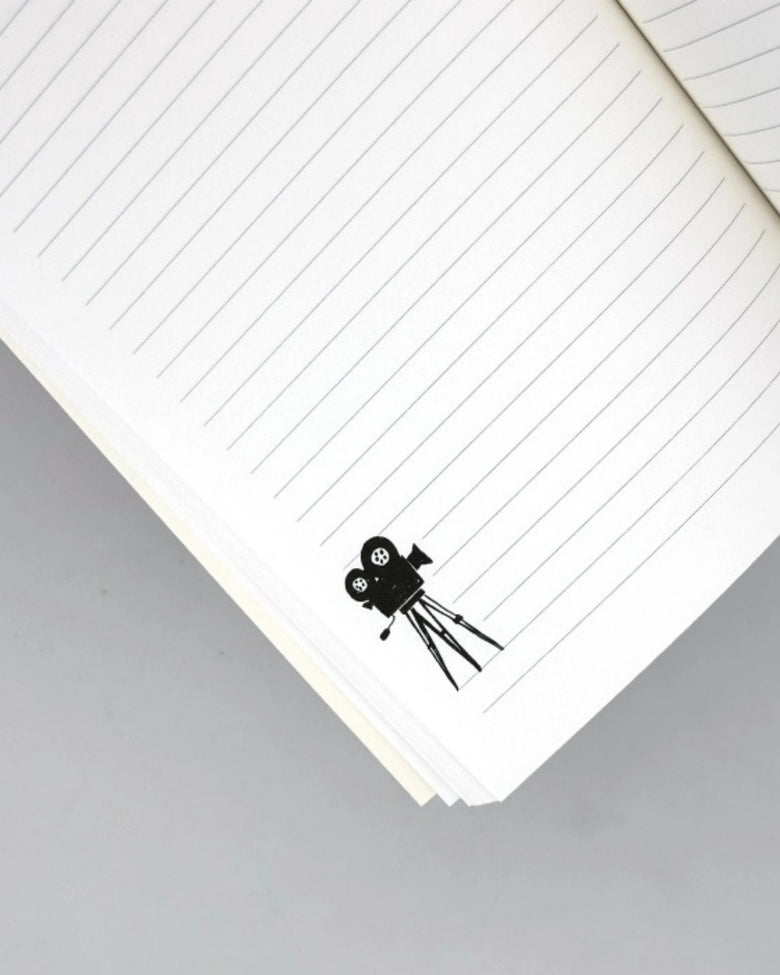 Lined journal page with a black movie-camera illustration near the bottom