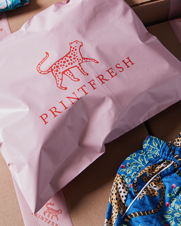 Pink PRINTFRESH packaging with a spotted leopard logo beside a blue patterned garment